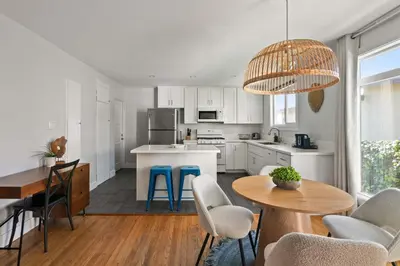 a kitchen with white cabinets and a table and chairs at Pacific Beach Gem Walk to Law Street Beach in San Diego
