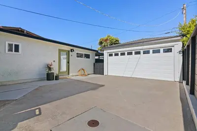 a house with two garage doors and a driveway at Pacific Beach Studio Short Walk to Ocean in San Diego