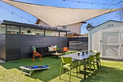 a patio with a table and chairs on the grass at Pacific Beach Studio Short Walk to Ocean in San Diego