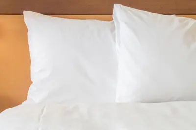 a bed with white sheets and two pillows at Holiday Inn Express & Suites San Diego - Mission Valley by IHG in San Diego