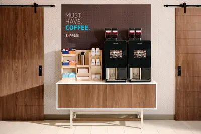 a coffee shop with a counter with a coffee maker on it at Holiday Inn Express & Suites San Diego - Mission Valley by IHG in San Diego