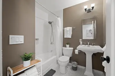 a bathroom with a white toilet and a sink at City Lights and Rooftop Nights by Rather Be Properties in San Diego