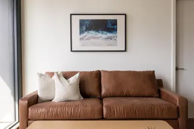 a brown couch in a living room with a picture at Kasa Little Italy San Diego in San Diego