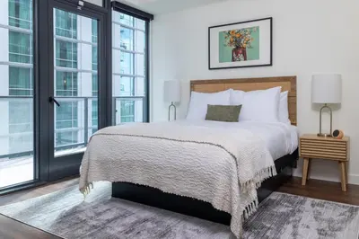 a bedroom with a large bed and large windows at Kasa Little Italy San Diego in San Diego