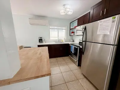 a kitchen with a stainless steel refrigerator and wooden cabinets at Charming Ocean Beach 2BR in San Diego