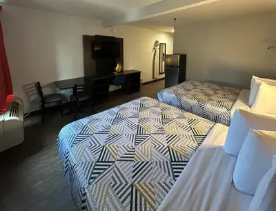 a hotel room with two beds and a desk at Studio 6 San Diego, CA Hotel Circle Mission Valley in San Diego