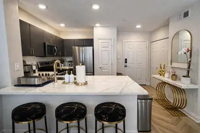 a kitchen with a large island with two bar stools at Allura Little Italy - 2 BR in Downtown's Top Spot in San Diego