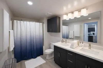 a bathroom with a sink and a toilet and a mirror at Allura Little Italy - 2 BR in Downtown's Top Spot in San Diego