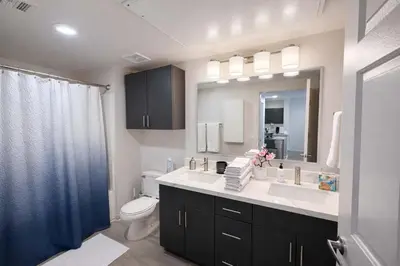 a bathroom with a sink and a toilet and a mirror at Allura Little Italy - 2 BR in Downtown's Top Spot in San Diego