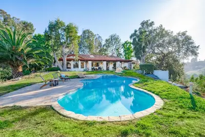 an estate with a swimming pool in front of a house at Casa Via Zara - Sweeping Mountain Views with Pool in Fallbrook