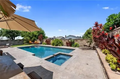 a swimming pool in a backyard with an umbrella at Anselmo in Mission Viejo