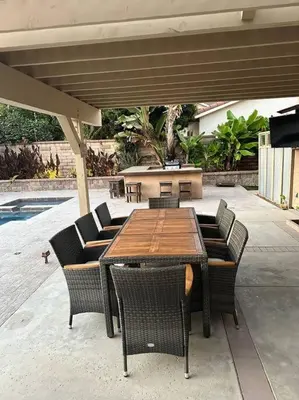 a wooden table and chairs under an umbrella at Anselmo in Mission Viejo