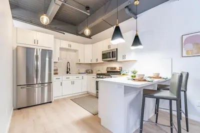 a kitchen with white cabinets and stainless steel appliances at Gorgeous Villa Steps to La Jolla Cove in San Diego