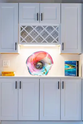 a kitchen with white cabinets with a painting on the wall at Gorgeous Villa Steps to La Jolla Cove in San Diego