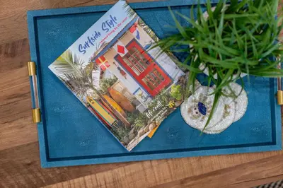 a magazine sitting on a table next to a vase with a plant at Gorgeous Villa Steps to La Jolla Cove in San Diego