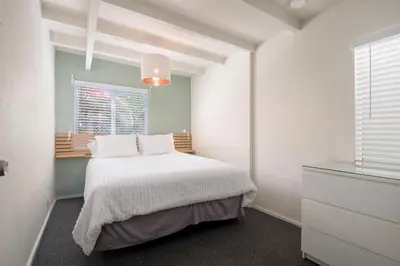 a white bedroom with a bed and a window at Sandy Toes in San Diego