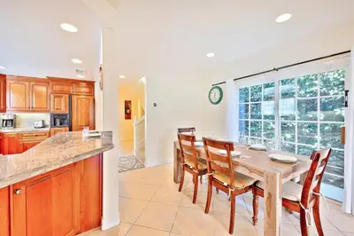 a dining room with a table and chairs and a kitchen at Beach Happy in San Diego