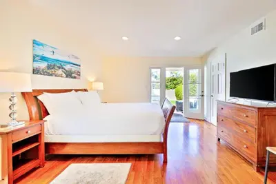 a bedroom with a large bed and a television at Beach Happy in San Diego