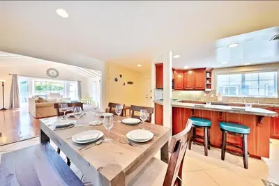 a kitchen and dining room with a wooden table and chairs at Beach Happy in San Diego