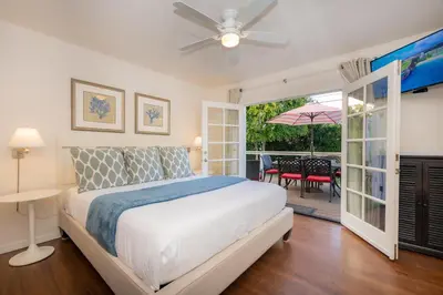 a white bedroom with a bed and a patio at Las Palmas Escape in San Diego