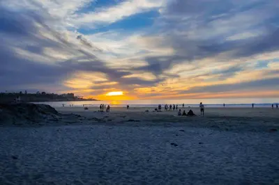a group of people on a beach at sunset at Sandy Shores Beach House in San Diego
