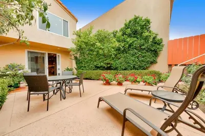a patio with chairs and tables and a building at Village and Views in San Diego