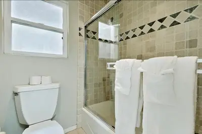 a bathroom with a toilet and a shower with towels at Village and Views in San Diego