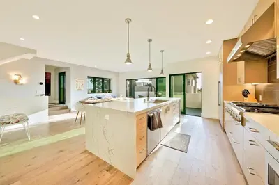 a large kitchen with white cabinets and a large island at Sunny Shores in San Diego