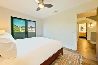 a white bedroom with a bed and a ceiling fan at Sunny Shores in San Diego