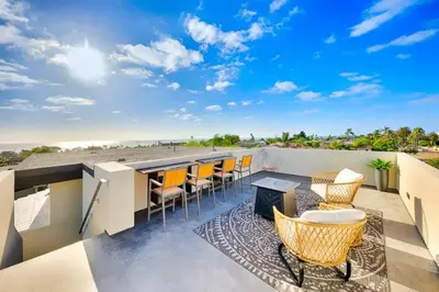a patio with chairs and a bar on a roof at Sunny Shores in San Diego