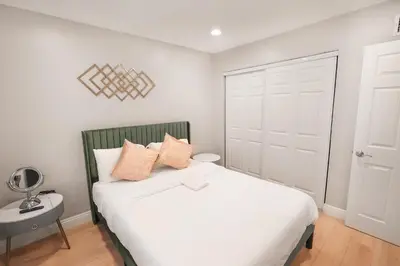 a bedroom with a bed with white sheets and orange pillows at 8354 Adam Unit A 2b 1b by sdstay in Lemon Grove