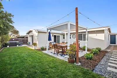 a house with a patio with a table in the yard at Family Oasis with Hot Tub and Dedicated Workspace in San Diego