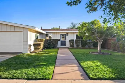 a white house with a tree and a driveway at Family Oasis with Hot Tub and Dedicated Workspace in San Diego