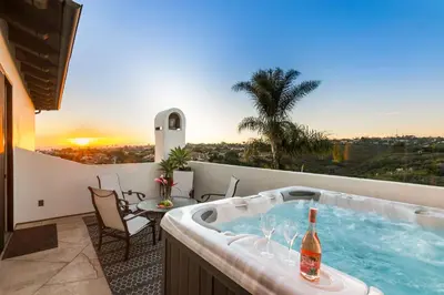 a hot tub on the balcony of a house at Timeless Spanish Villa with Panoramic Ocean Views in San Diego
