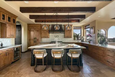 a kitchen with a large island with bar stools at Timeless Spanish Villa with Panoramic Ocean Views in San Diego