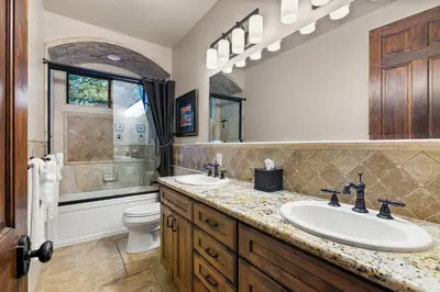 a bathroom with a sink and a toilet and a mirror at Timeless Spanish Villa with Panoramic Ocean Views in San Diego