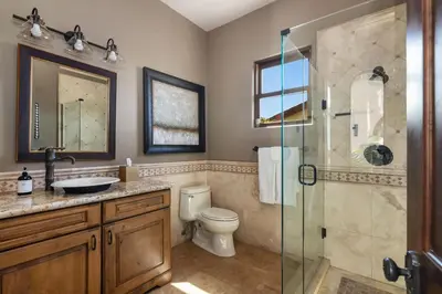 a bathroom with a toilet and a glass shower at Timeless Spanish Villa with Panoramic Ocean Views in San Diego