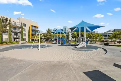 a playground with swings and umbrellas in a park at King Bed, Pool, Hot Tub, Arcade Room, Gym, Parking in San Diego