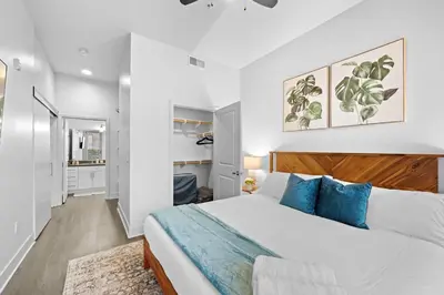 a bedroom with a large white bed with blue pillows at King Bed, Pool, Hot Tub, Arcade Room, Gym, Parking in San Diego