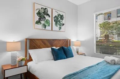 a bedroom with a bed and two lamps and a window at King Bed, Pool, Hot Tub, Arcade Room, Gym, Parking in San Diego