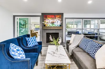 a living room with blue couches and a fireplace at Mission Valley Home 5 Mi to SDSU Campus in San Diego