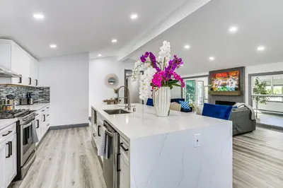 a kitchen with white cabinets and a vase of flowers at Mission Valley Home 5 Mi to SDSU Campus in San Diego