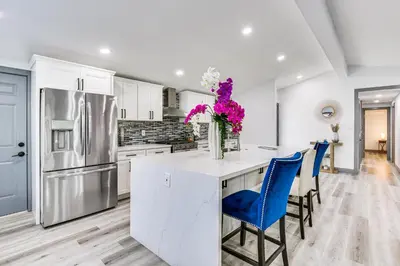 a kitchen with white cabinets and blue chairs at Mission Valley Home 5 Mi to SDSU Campus in San Diego