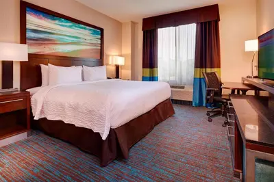 a hotel room with a bed and a flat screen tv at Fairfield Inn & Suites by Marriott San Diego Carlsbad in Carlsbad