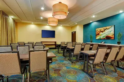 a conference room with tables and chairs and a screen at Fairfield Inn & Suites by Marriott San Diego Carlsbad in Carlsbad