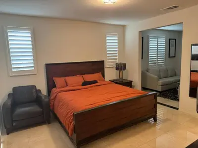 a bedroom with a large bed and a chair at Luxury 1200 sqft 1bdrm retreat with den in Menifee