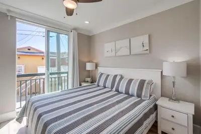 a bedroom with a bed and a large window at Steps 2 Ocean & Bay Luxury Belmont Park Dining in San Diego