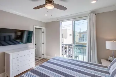a bedroom with a bed and a window with a balcony at Steps 2 Ocean & Bay Luxury Belmont Park Dining in San Diego