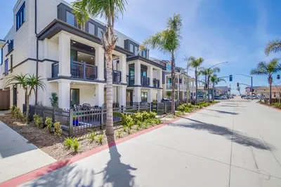 a building with palm trees in front of a street at Steps 2 Ocean & Bay Luxury Belmont Park Dining in San Diego