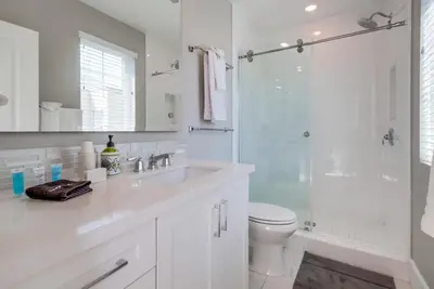 a white bathroom with a sink and a shower at Steps 2 Ocean & Bay Luxury Belmont Park Dining in San Diego